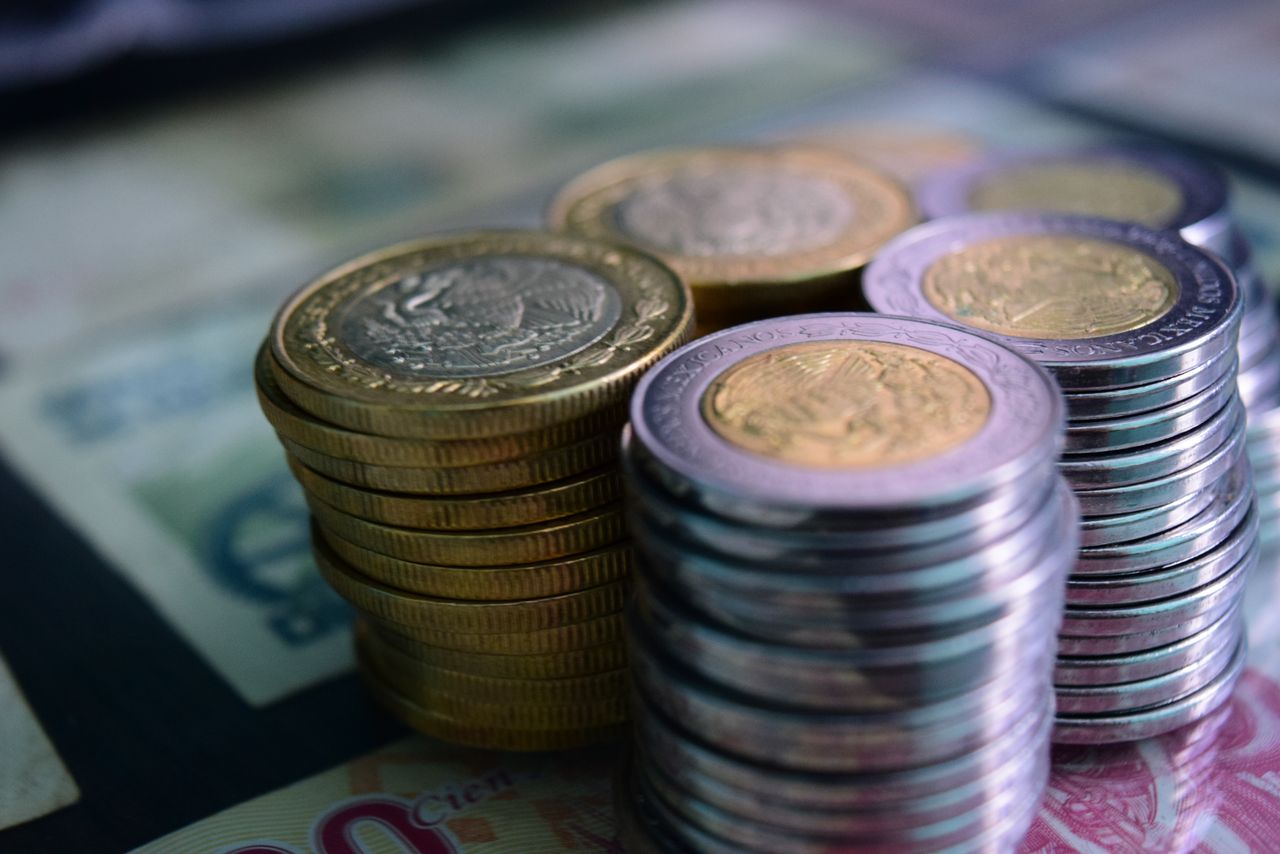 Pilas de monedas sobre billetes